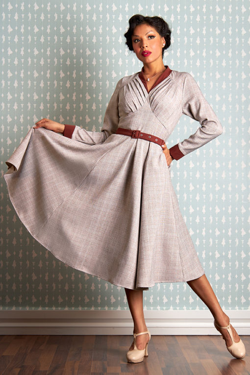 robe swing années 50, couleur parme avec contrastes rouille, avec poches, de face, robe tendue d'une main, Station Vintage, fond vintage