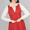 Femme souriante en gilet rouge et chemise blanche.