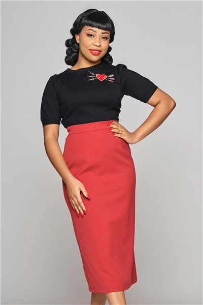 Femme portant une jupe crayon rouge et un haut noir, main sur la hanche, Station Vintage