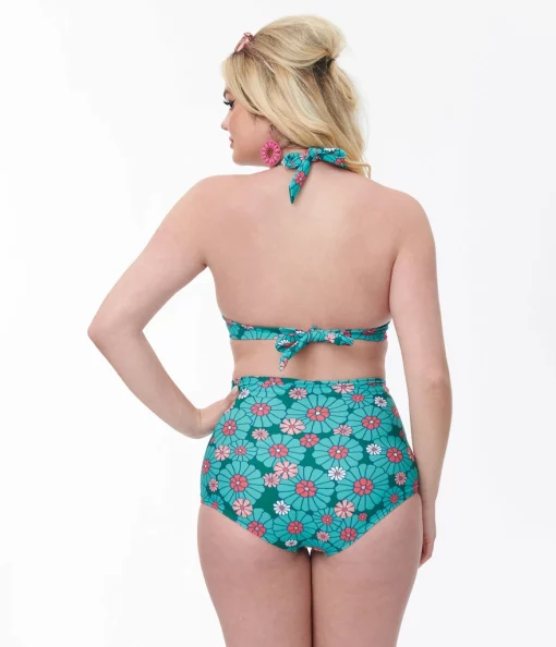Femme blonde avec main sur la hanche affiche le Bas de maillot de bain bleu à fleurs style naïf, 50's, de dos Station Vintage