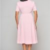 Femme de dos pour présenter la robe évasée rose disponible chez Station Vintage